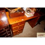 A pine knee hole desk fitted with four drawers