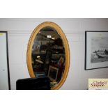 A gilt framed bevel edged oval wall mirror