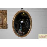 An oval bevel edged gilt framed mirror