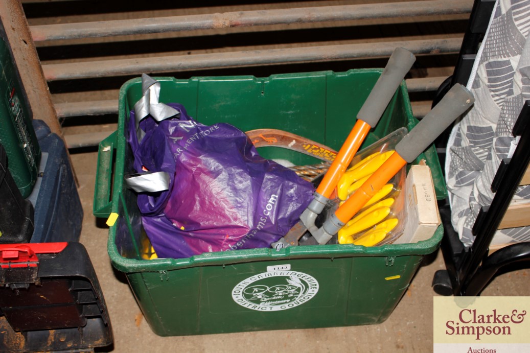 A plastic container of garden tools, paint brushes