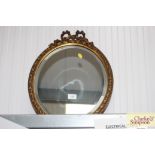 A gilt framed oval bevel edged wall mirror