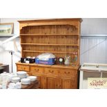 A pine dresser raised on cupboard base fitted four