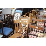 A set of four elm seated stick back dining chairs;