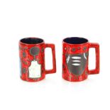 A pair of red glazed pottery mugs, having stylised