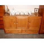 An Ercol sideboard, the interior shelf and cutlery