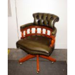 A 20th Century swivel desk chair, with buttoned gr