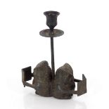 A vintage metal candlestick in the form of seated