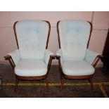 A pair of Ercol cottage style stick back wing armchairs