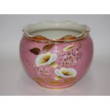 A large pink glazed jardinière, having floral deco