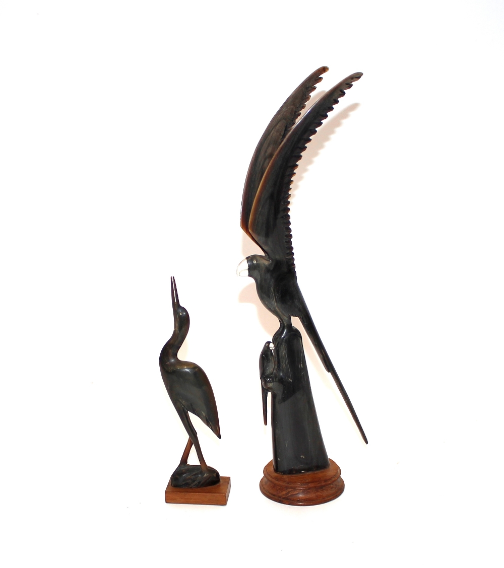 A carved horn model of a parrot; and another of a