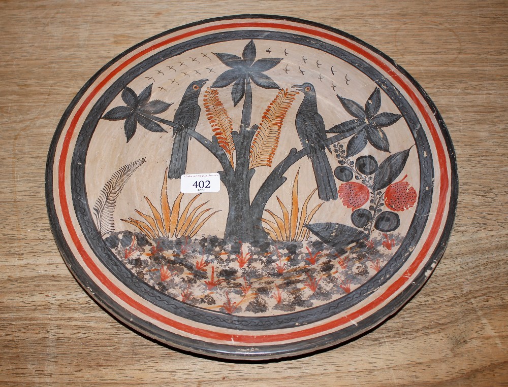 A Mexican pottery charger, decorated with birds am