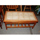 A teak tile top oblong coffee table with magazine