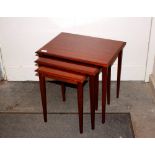 A nest of three teak occasional tables, raised on