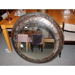 A large metal industrial style circular wall mirro