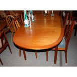 A teak extending dining table with central folding