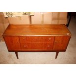 A teak sideboard fitted two central drawers, flank