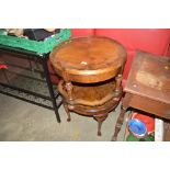 A walnut circular topped table; and one other