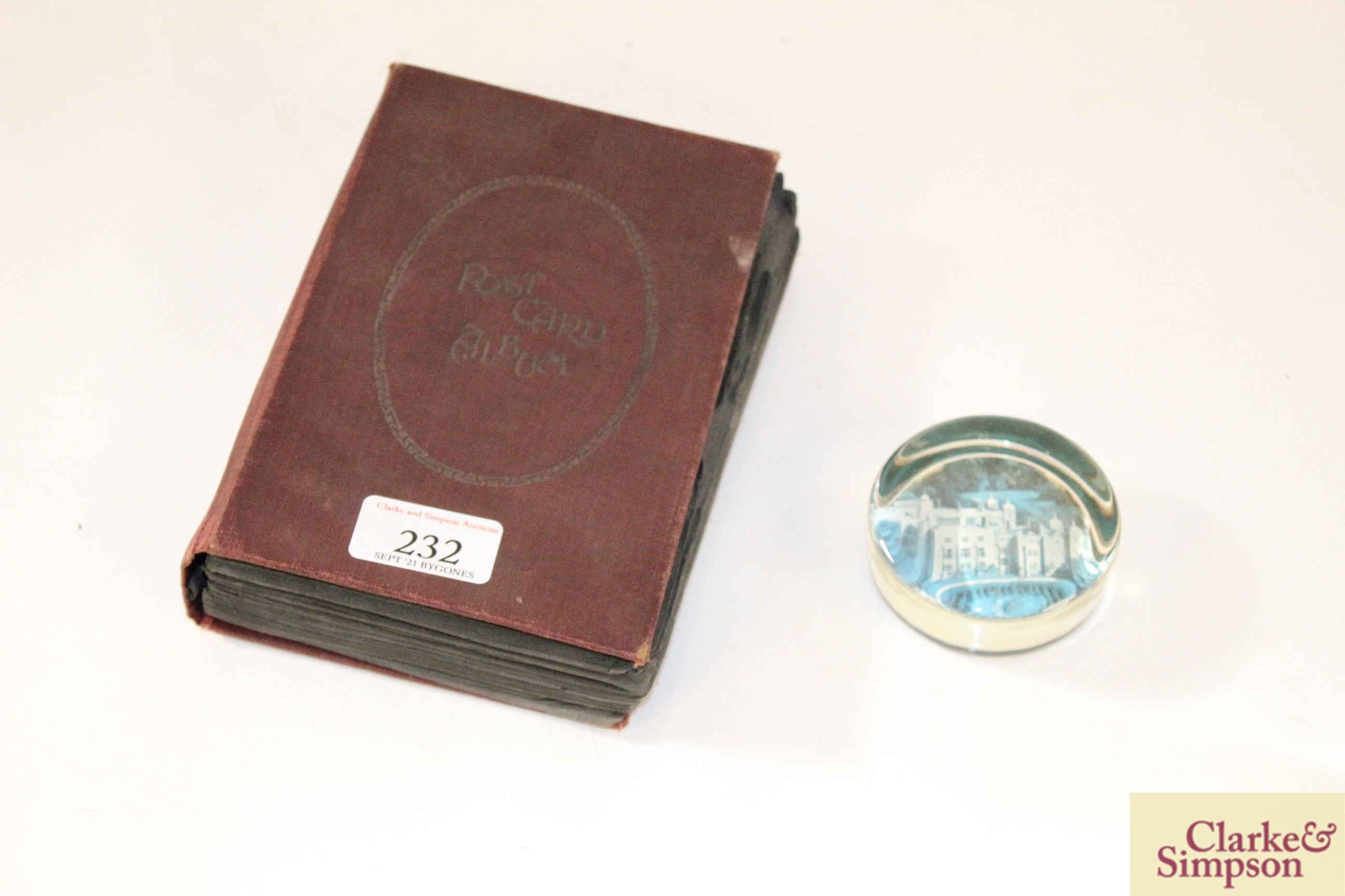 A small glass paperweight and a post-card album co