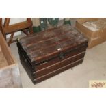 A vintage wooden trunk with metal mounts and carry