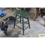 A rustic green painted wooden stool