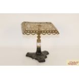 An antique brass hearth stand on cast iron base
