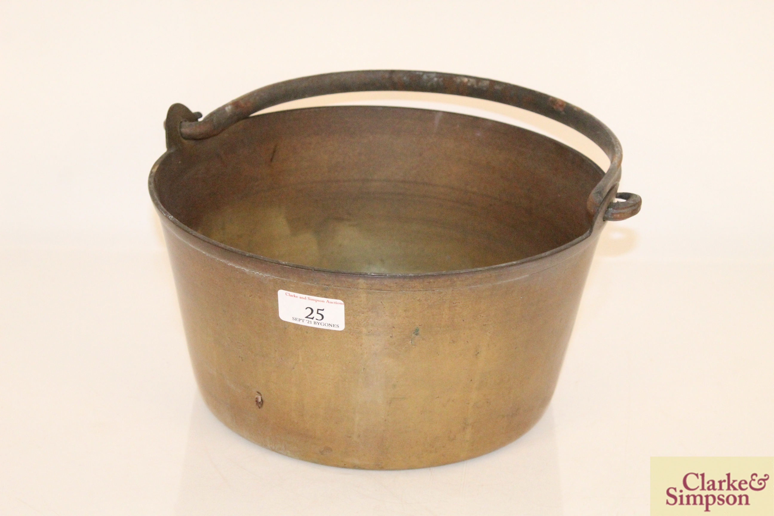 A heavy brass preserve pan with swing handle