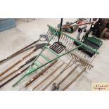 A large green painted drag rake