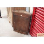 An antique oak hanging corner cupboard