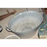 A galvanised twin handled bath