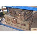 A canvas and leather wheeled trunk and a strapped