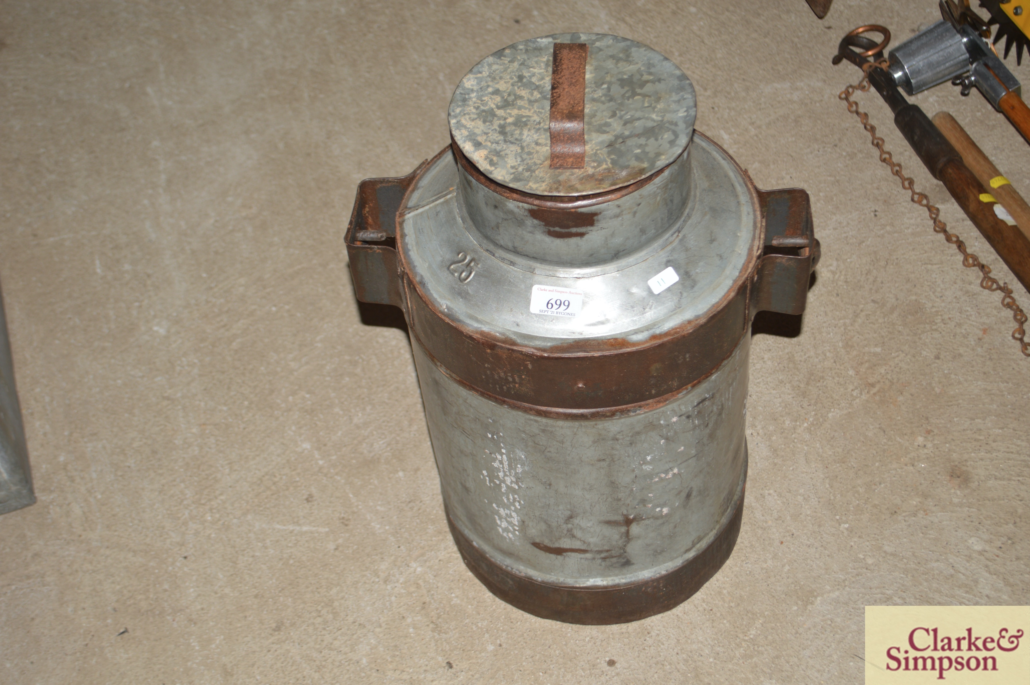A galvanised and iron milk churn with lid and swin