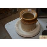 A stoneware kitchen jar and a pottery bread platt