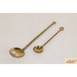 An antique brass ladle and a smaller similar