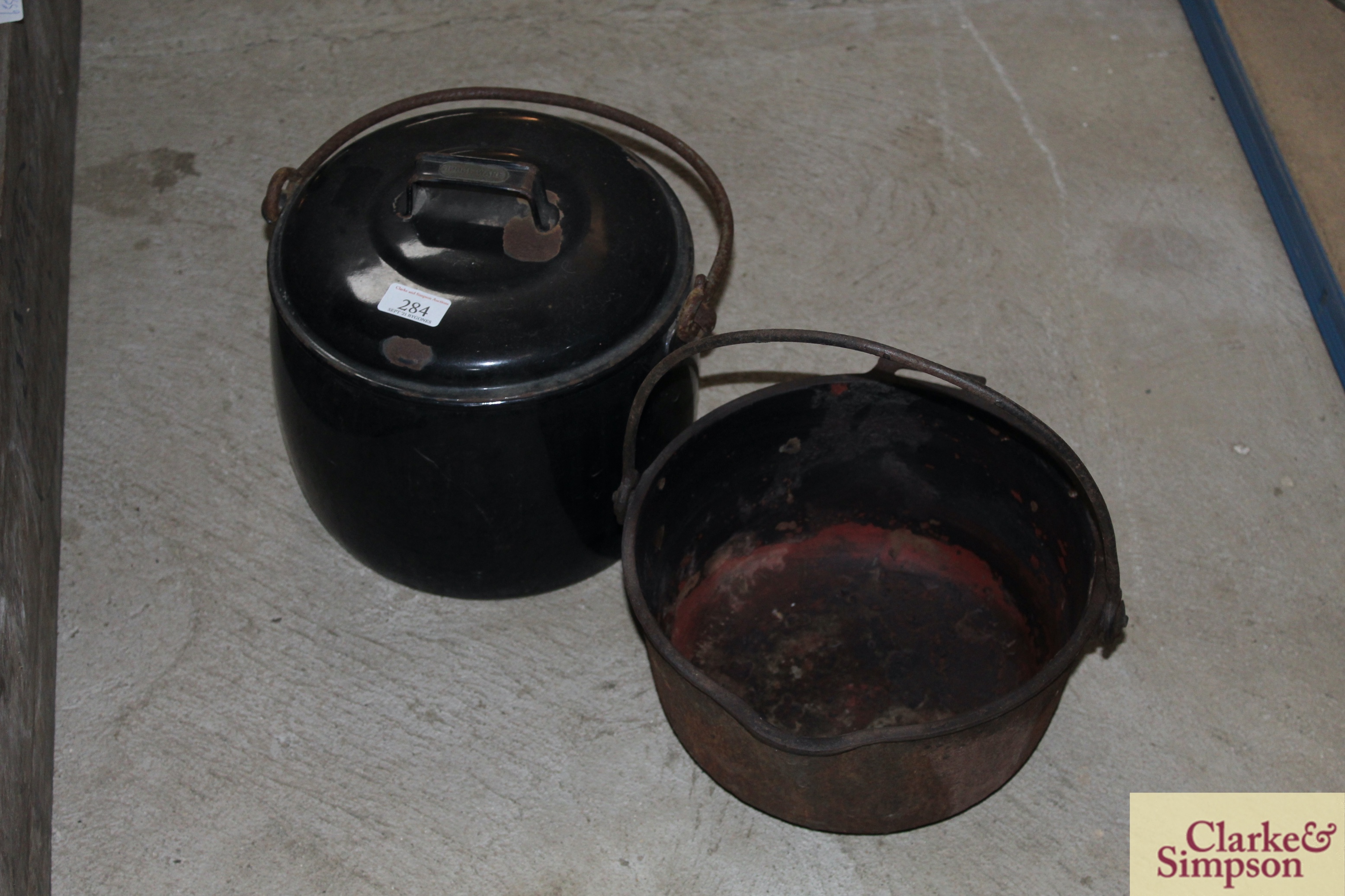 A black enamel cooking pot and lid with swing hand