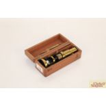 A small brass medical slide viewer in fitted wooden case, with brass slide handling tool