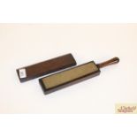 An antique oak cased razor strop