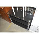 A black glass three tier TV stand