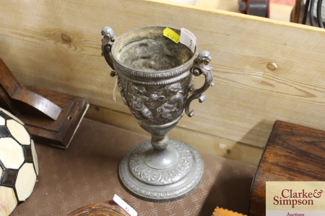 A pewter goblet with cherub decoration