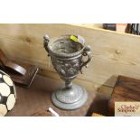 A pewter goblet with cherub decoration