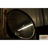 An oval gilt framed bevel edged wall mirror