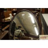 An oval mahogany framed bevel edged wall mirror