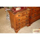 A walnut and chequer banded bedside chest fitted t