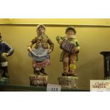 A pair of continental pottery figures of street en