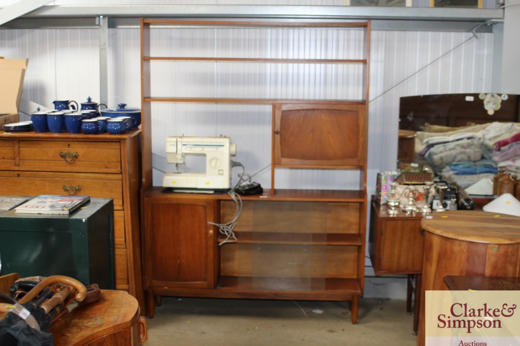 A teak shelving unit with glass sliding doors