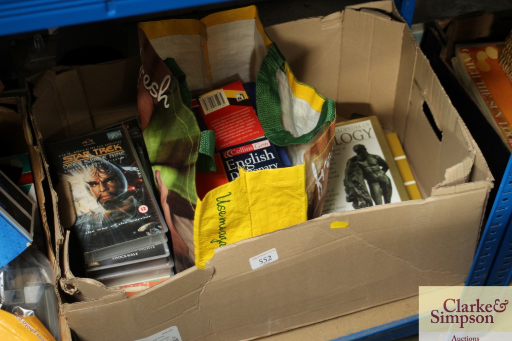 A box containing various books and VHS tapes