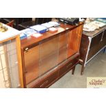 A teak display case with glass sliding doors fitte