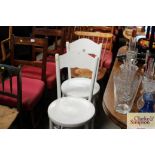 A pair of white painted poker decorated chairs and