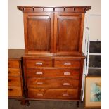 A Padauk wood Arts & Crafts design cabinet on chest, the upper section fitted shelves and enclosed