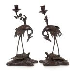 A pair of Japanese Meji bronze candlesticks, in the form of cranes stood on turtles, 38cm high