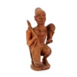 An unusual ethnic carving of crouching bearded figure, carrying weapon and food, 49cm high